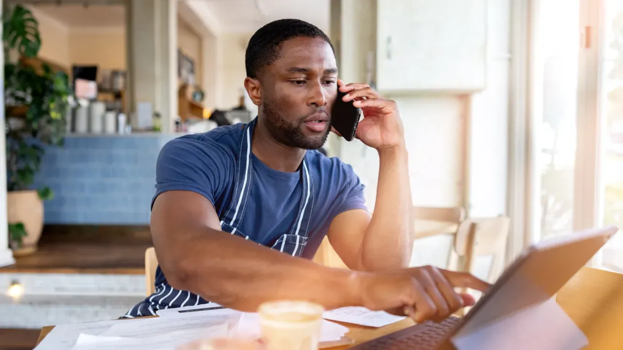 Man business owner on phone working at computer