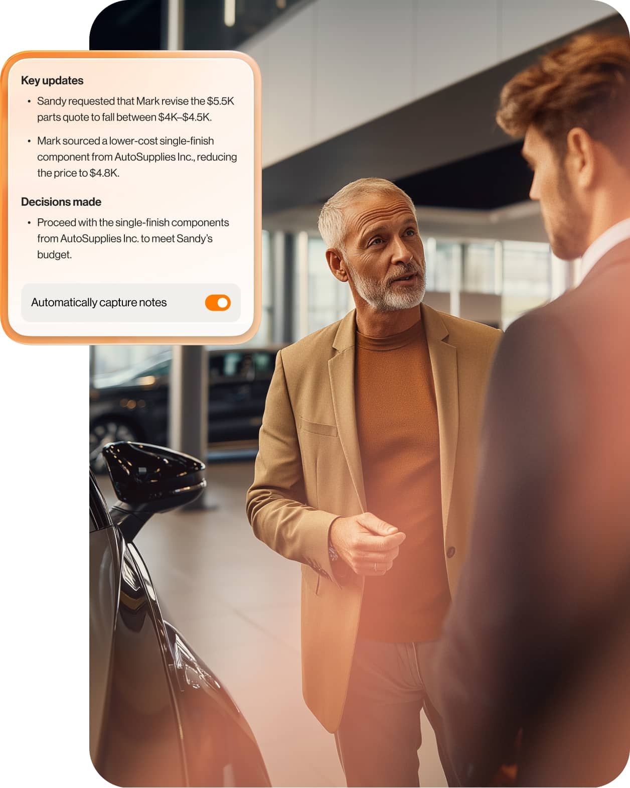 Dealership employee and a customer stand next to a car, talking.