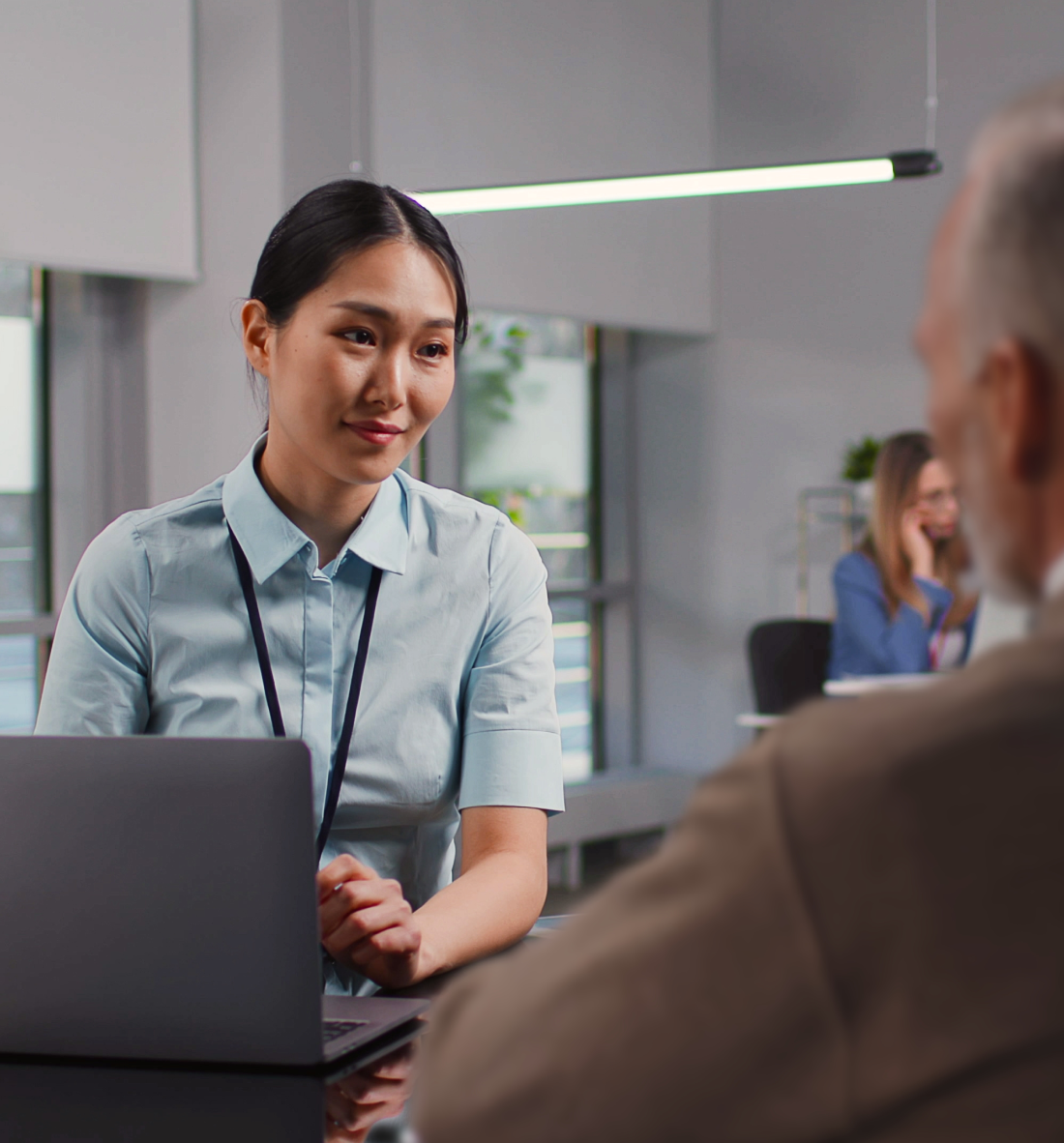 A smiling bank employee speaks to a customer