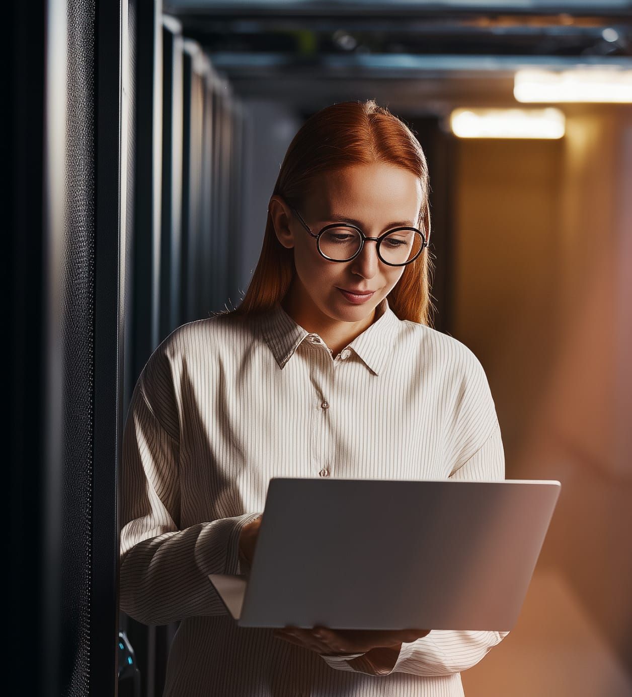 A woman works on a laptop in an office.